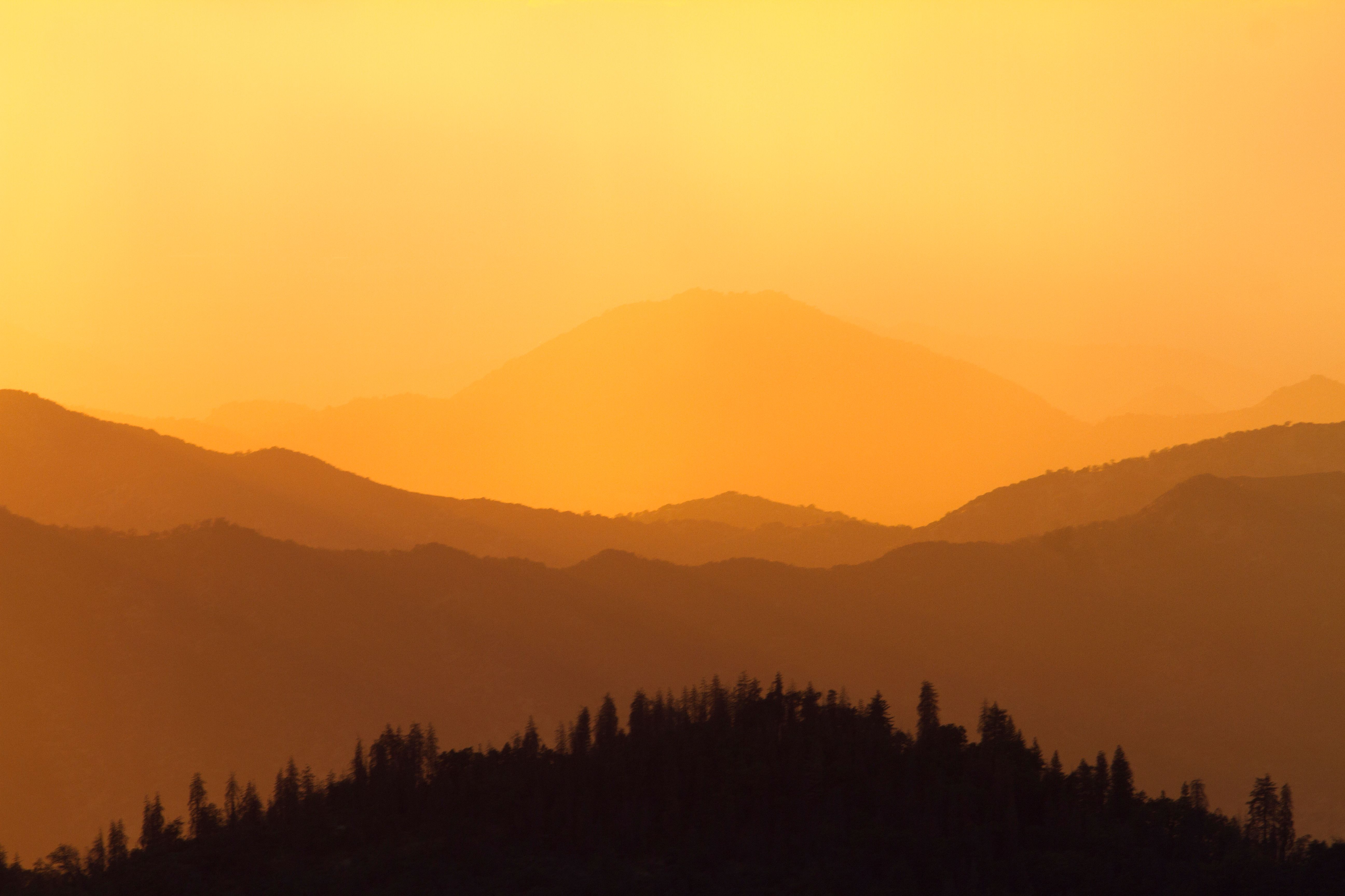 Hazy amber sky over mountain silhouettes